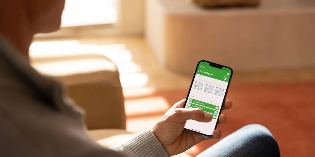 Man holding PowerView® Automation remote for automatic blinds at Nest Expressions near Wexford, PA